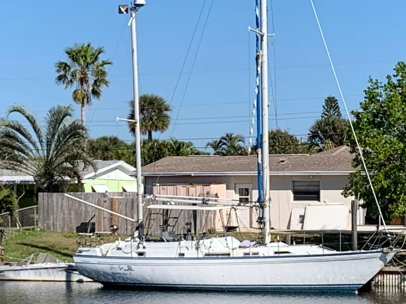 Slide: The Image of 1978 Camper & Nicholsons Sloop docked near a house with palm trees. - 0