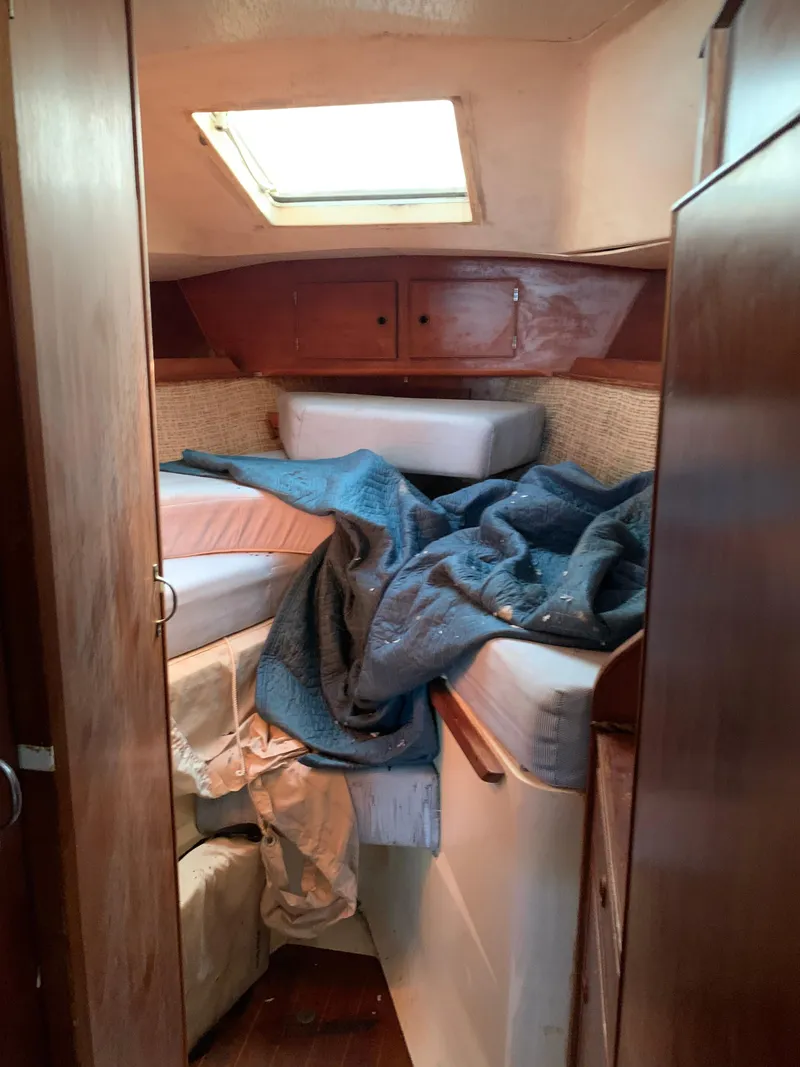Slide: The Image of 1978 Camper & Nicholsons Sloop cabin interior with unmade bed and wooden cabinetry. - 11