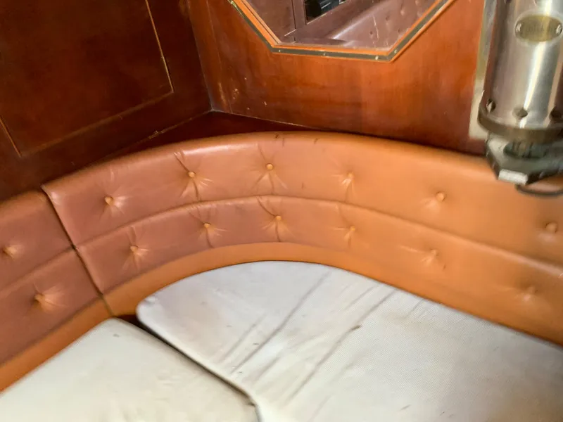 Slide: The Image of 1978 Camper & Nicholsons Sloop interior with curved leather seating and wooden paneling. - 13