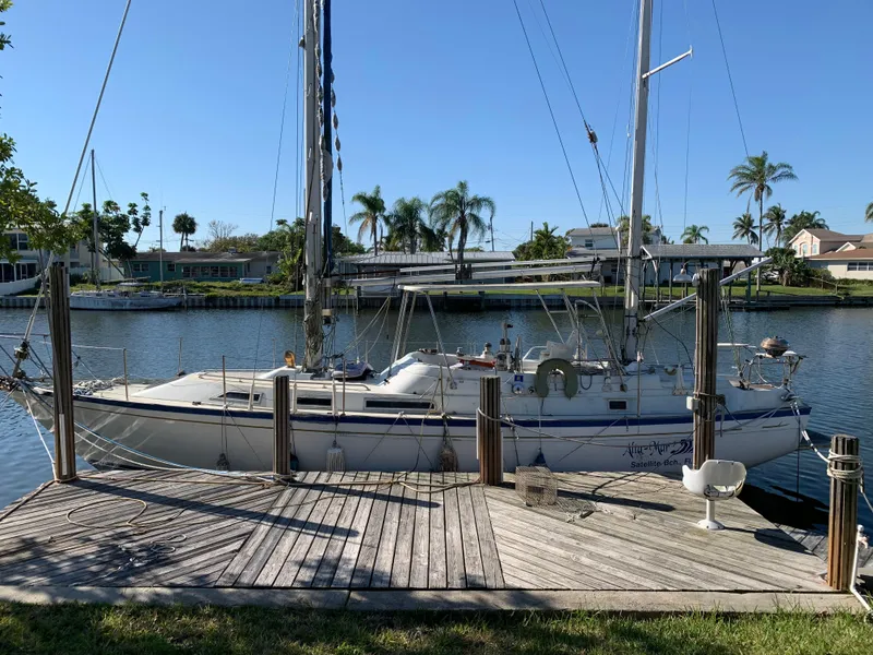 Slide: The Image of 1978 Camper & Nicholsons Sloop docked by a wooden pier, surrounded by palm trees. - 20