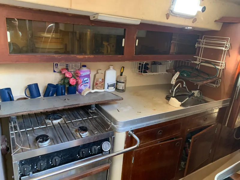 Slide: The Image of 1978 Camper & Nicholsons Sloop kitchen with stove, sink, and storage cabinets. - 6