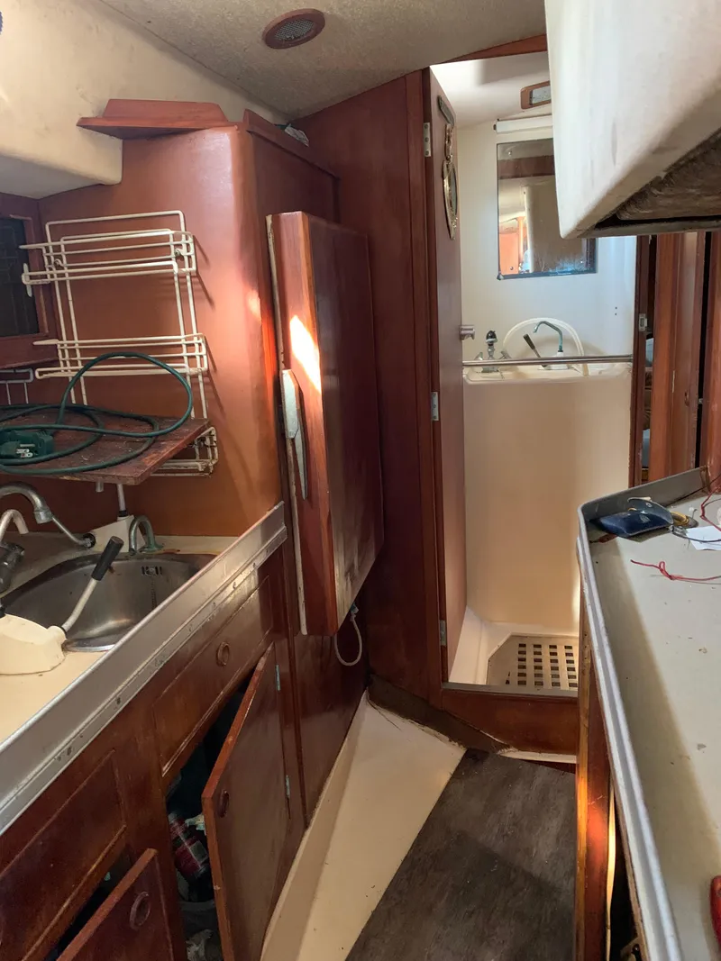 Slide: The Image of 1978 Camper & Nicholsons Sloop interior with wooden cabinetry and compact kitchen area. - 7