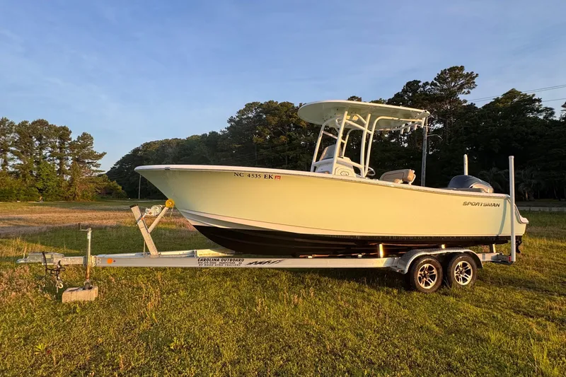 The Image of 2019 Sportsman 231 Heritage Platinum boat on trailer in grassy field. - 1