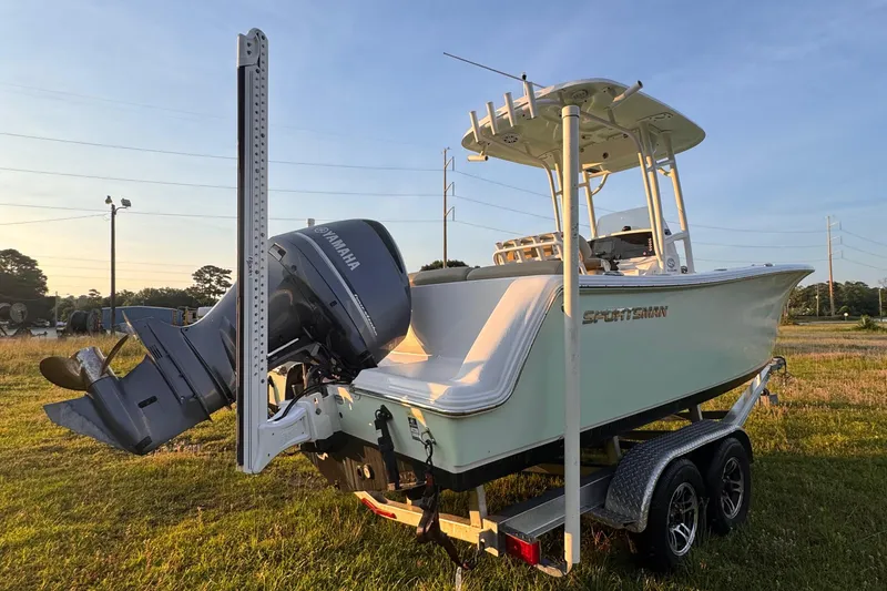 Slide: The Image of 2019 Sportsman 231 Heritage Platinum boat on trailer, Yamaha outboard, parked on grass. - 4