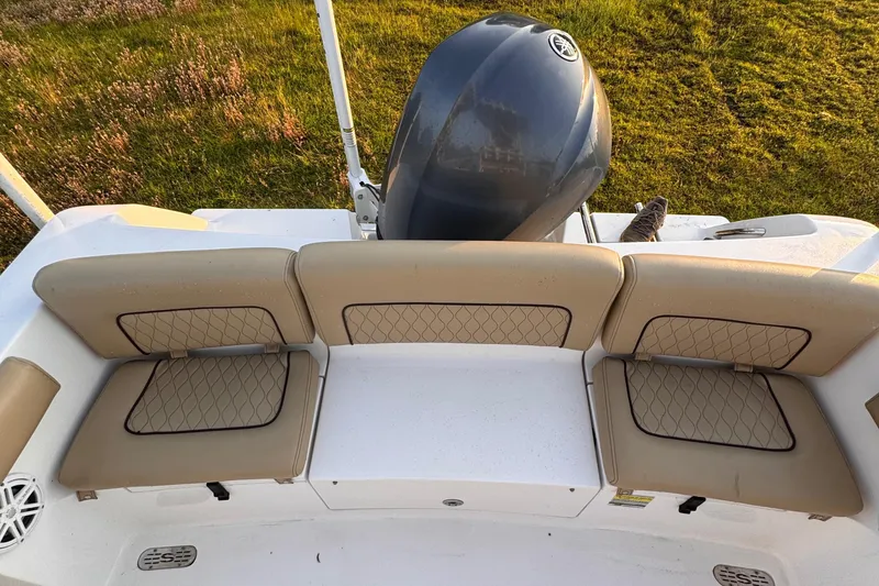 Slide: The Image of 2019 Sportsman 231 Heritage Platinum boat with cushioned seating and outboard motor. - 8