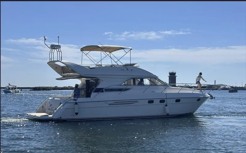 The Image of 1998 Viking Princess 46 Flybridge Sport Cruiser on calm water, sunny day, lighthouse in background. - 0