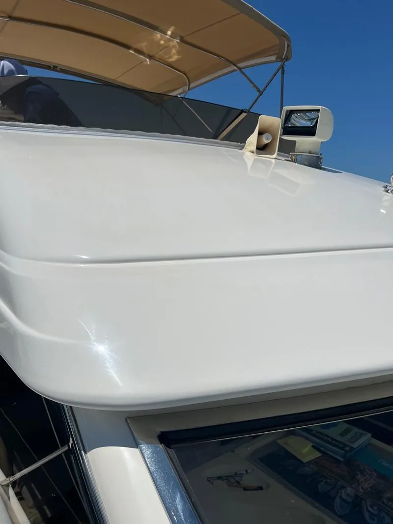 Slide: The Image of 1998 Viking Princess 46 Flybridge Sport Cruiser with sleek white exterior and sunshade. - 10