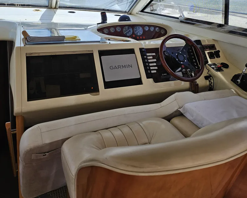 Slide: The Image of 1998 Viking Princess 46 Flybridge Sport Cruiser helm with Garmin navigation system and leather seating. - 14