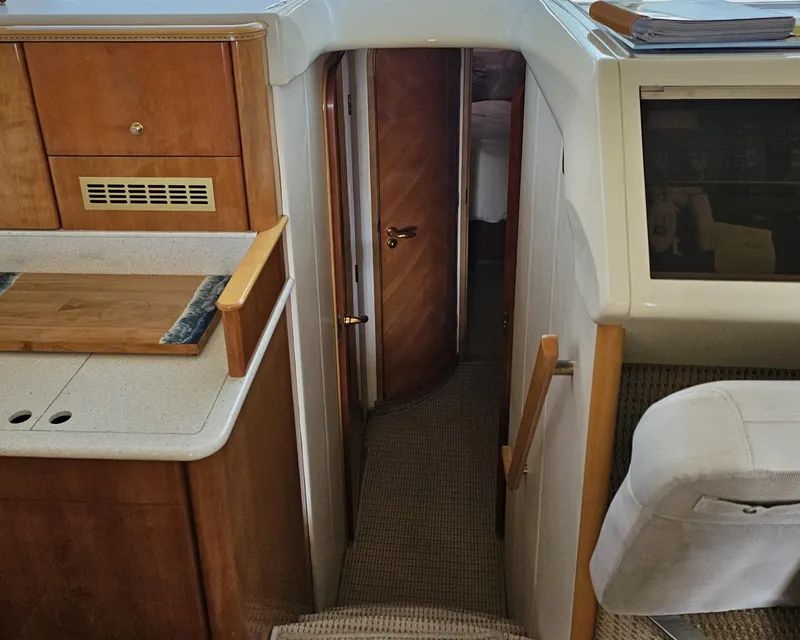 Slide: The Image of Interior of 1998 Viking Princess 46 Flybridge Sport Cruiser, featuring wood cabinetry and narrow hallway. - 15