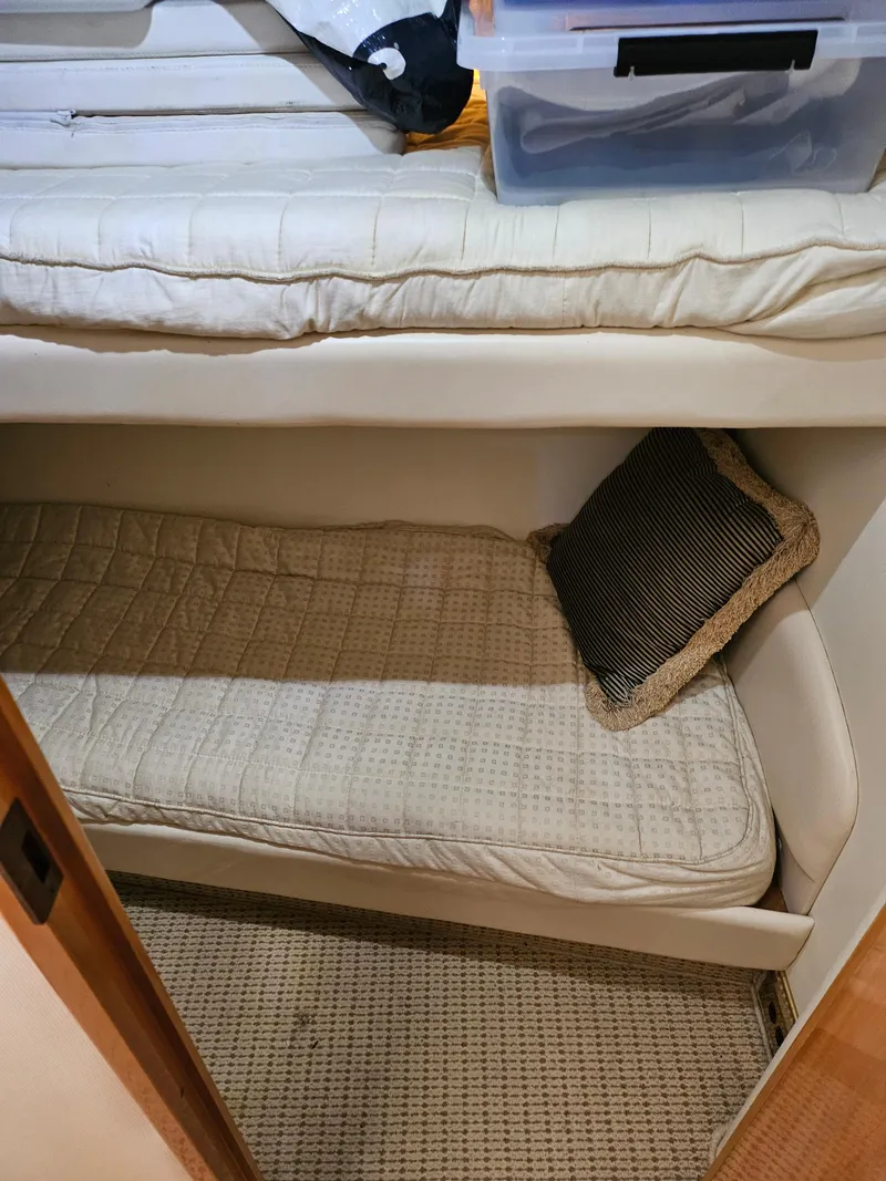 Slide: The Image of 1998 Viking Princess 46 Flybridge Sport Cruiser cabin with bunk beds and storage. - 17