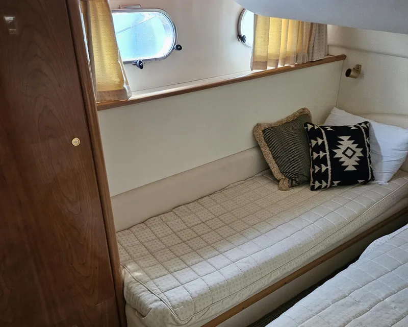 Slide: The Image of Cozy cabin interior of 1998 Viking Princess 46 Flybridge Sport Cruiser with cushions and porthole windows. - 18