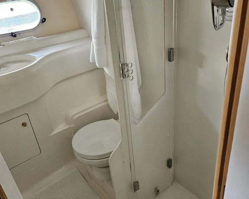 Slide: The Image of Bathroom interior of 1998 Viking Princess 46 Flybridge Sport Cruiser, featuring toilet and shower. - 19