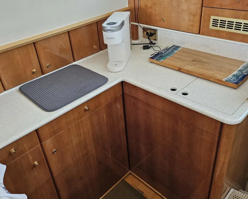 Slide: The Image of 1998 Viking Princess 46 Flybridge Sport Cruiser kitchen with wooden cabinets and countertop appliances. - 24