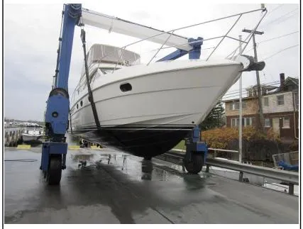 Slide: The Image of 1998 Viking Princess 46 Flybridge Sport Cruiser being lifted by a boat hoist. - 35