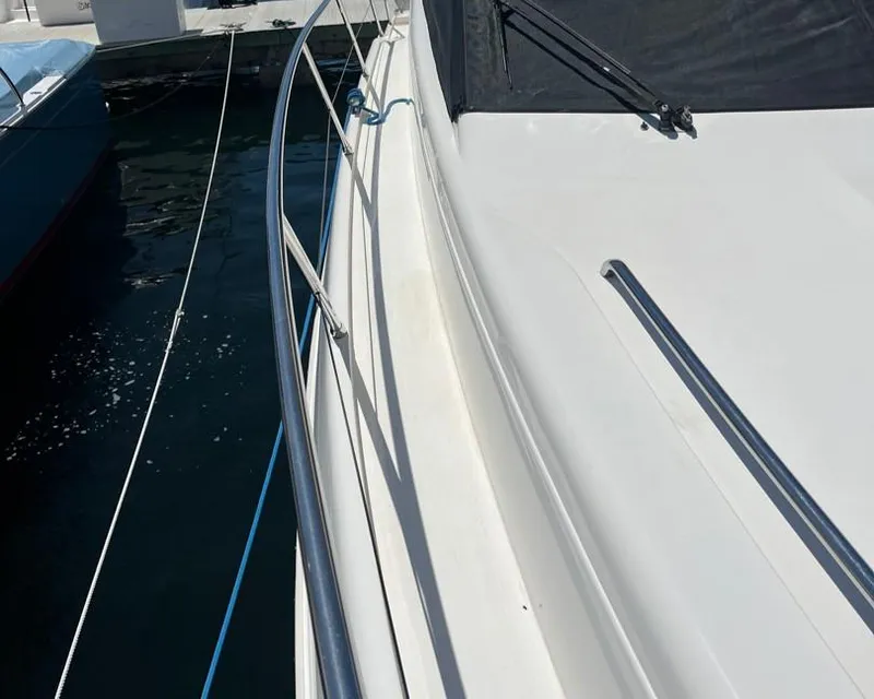 Slide: The Image of 1998 Viking Princess 46 Flybridge Sport Cruiser, side deck view with railing. - 6