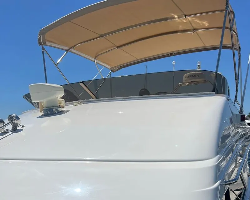 Slide: The Image of 1998 Viking Princess 46 Flybridge Sport Cruiser with beige canopy under clear blue sky. - 9