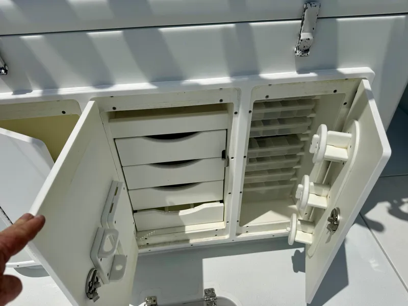 Slide: The Image of 2020 Yellowfin 39 Offshore boat storage compartments with open doors and organized shelves. - 12