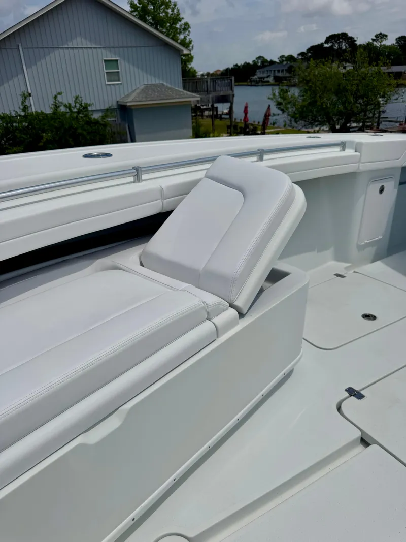 Slide: The Image of 2020 Yellowfin 39 Offshore boat with white seating, docked near a waterfront house. - 25