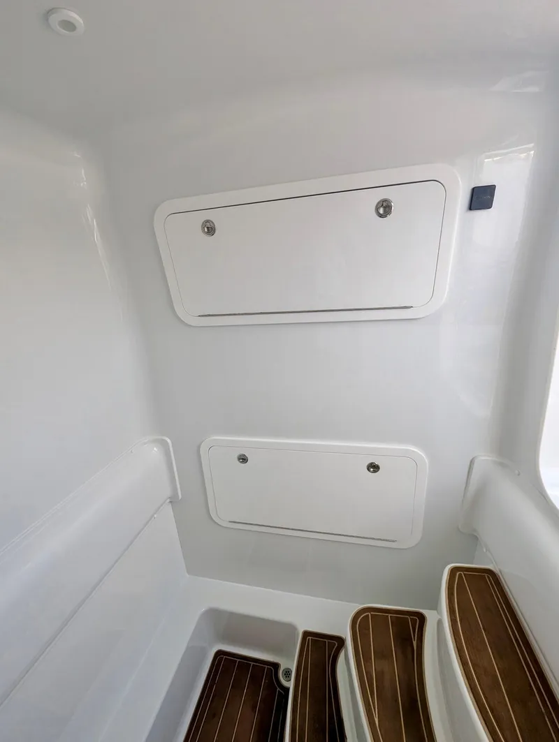 Slide: The Image of 2020 Yellowfin 39 Offshore interior with storage compartments and wooden steps. - 31