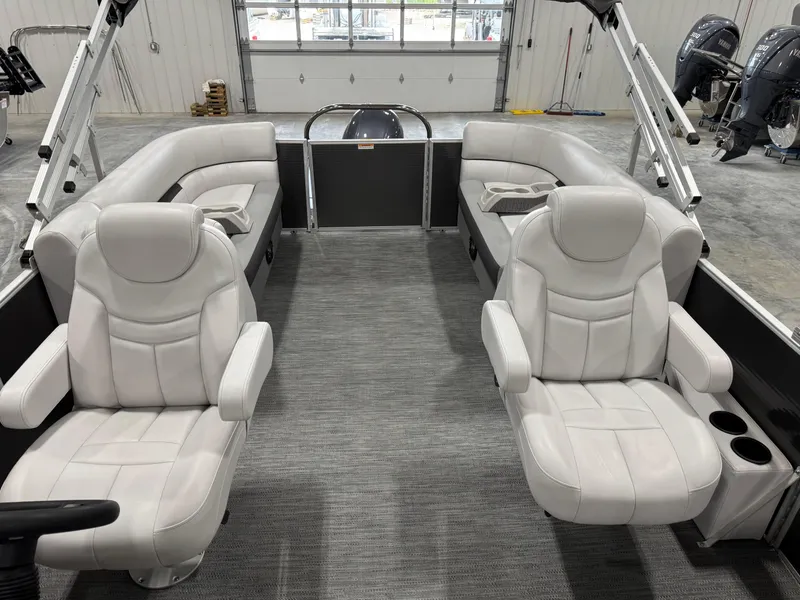 Slide: The Image of 2023 Sweetwater 2286 boat interior with plush seating and modern design in a showroom. - 10