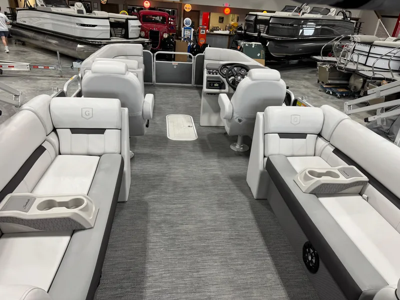 Slide: The Image of 2023 Sweetwater 2286 pontoon boat interior with gray seating and modern dashboard. - 14