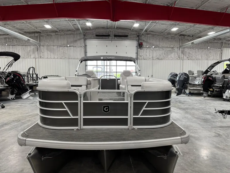 Slide: The Image of 2023 Sweetwater 2286 pontoon boat in a showroom, featuring sleek design and spacious seating. - 8