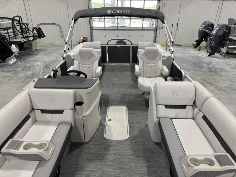 Slide: The Image of 2023 Sweetwater 2286 pontoon boat with spacious seating and modern design in a showroom. - 9