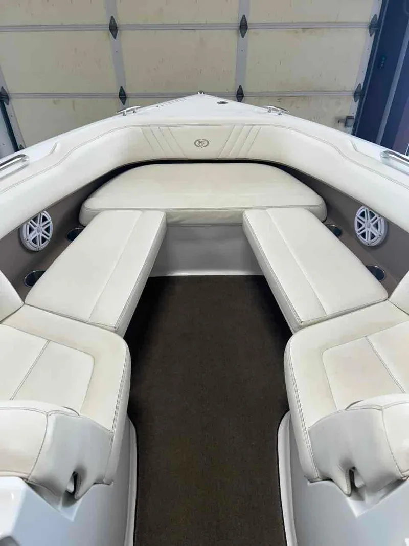Slide: The Image of 2008 Cobalt 232 boat interior with white cushioned seating and built-in speakers. - 2