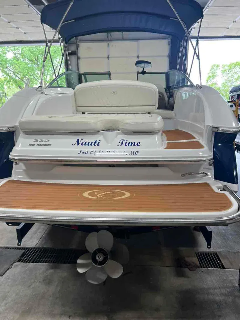Slide: The Image of 2008 Cobalt 232 boat named "Nauti Time" in a garage, featuring teak swim platform. - 4