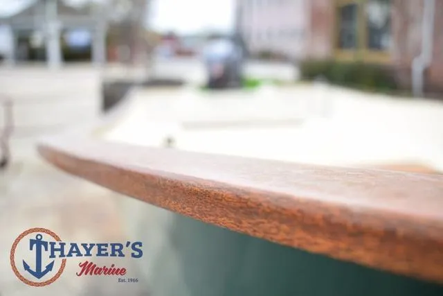 Slide: The Image of 1980 Carolina Skiff boat detail with Thayer's Marine logo, showcasing wooden edge craftsmanship. - 8