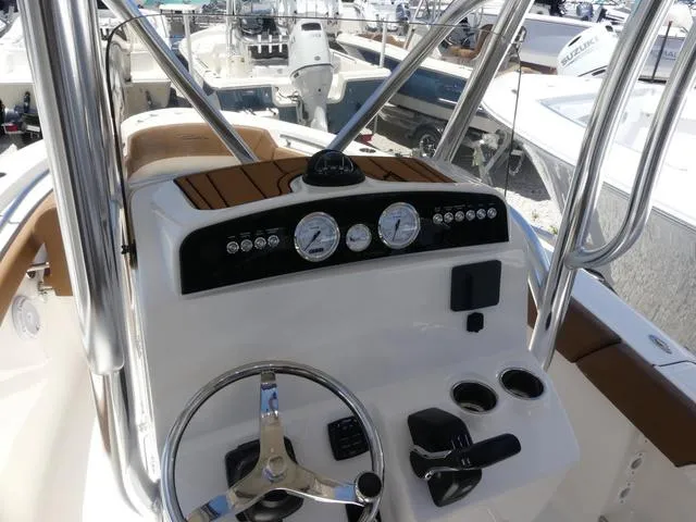 Slide: The Image of 2025 Pioneer ISLANDER 202 boat dashboard with steering wheel and gauges. - 14