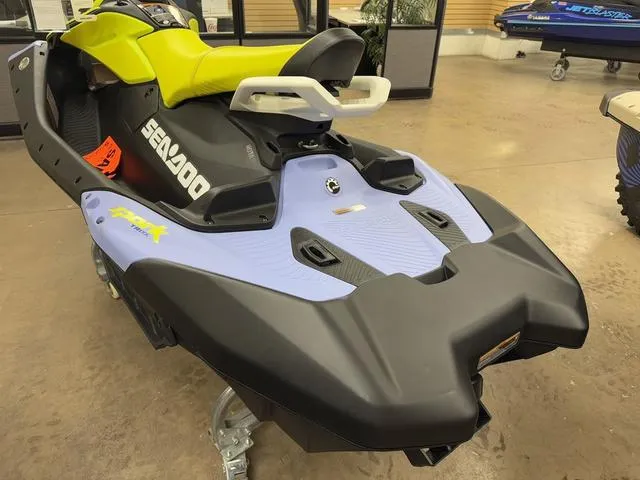 Slide: The Image of 2024 Sea-Doo Spark Trixx Waverunner in showroom, front view, red and white design. - 5