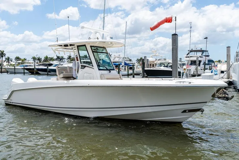 The Image of 2020 Boston Whaler 280 Outrage boat docked in a marina under a partly cloudy sky. - 0