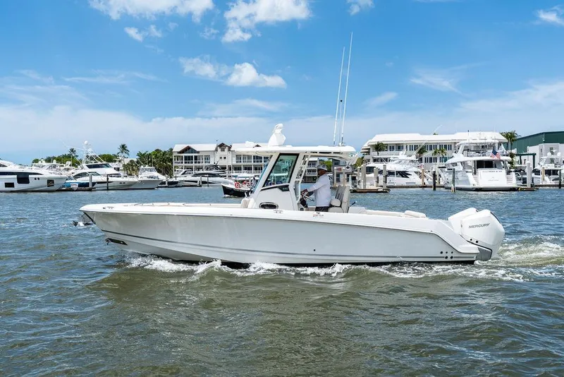 Slide: The Image of 2020 Boston Whaler 280 Outrage boat cruising in a marina under a clear blue sky. - 10