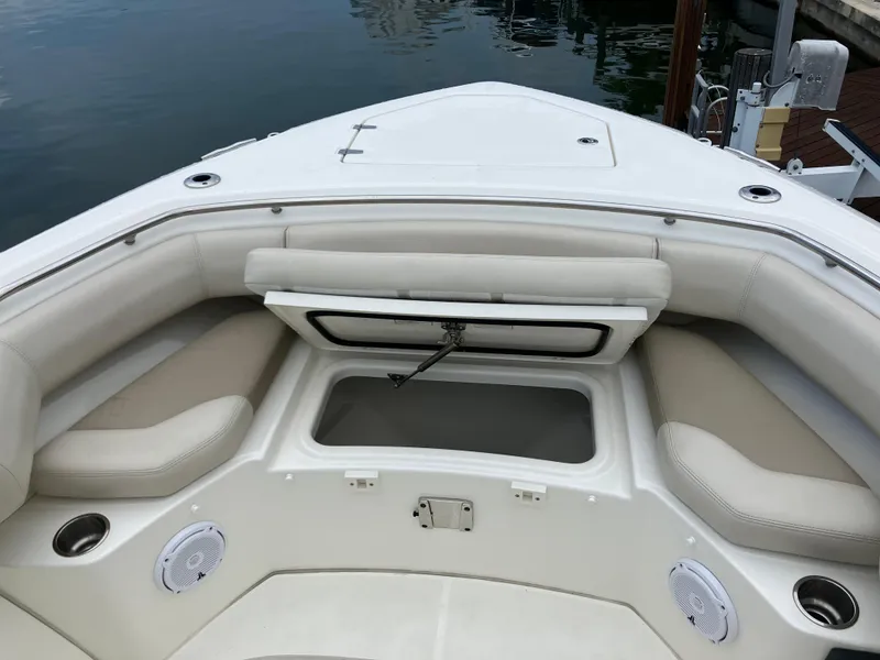 Slide: The Image of 2020 Boston Whaler 280 Outrage boat interior with cushioned seating and storage compartment. - 33