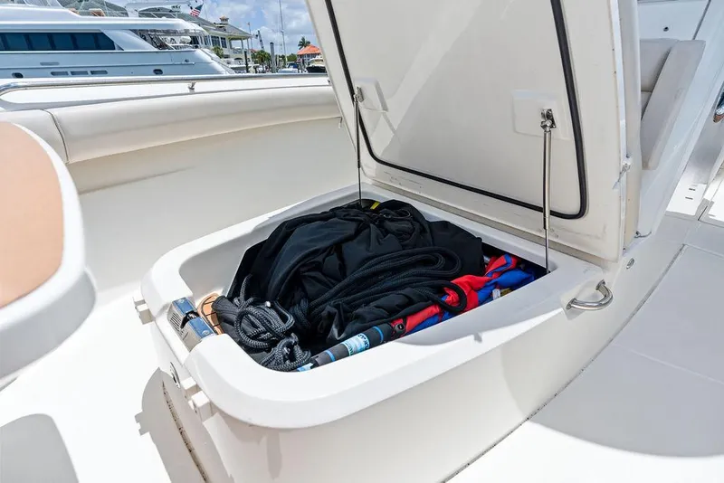 Slide: The Image of Open storage compartment on 2020 Boston Whaler 280 Outrage boat, containing gear and equipment. - 34