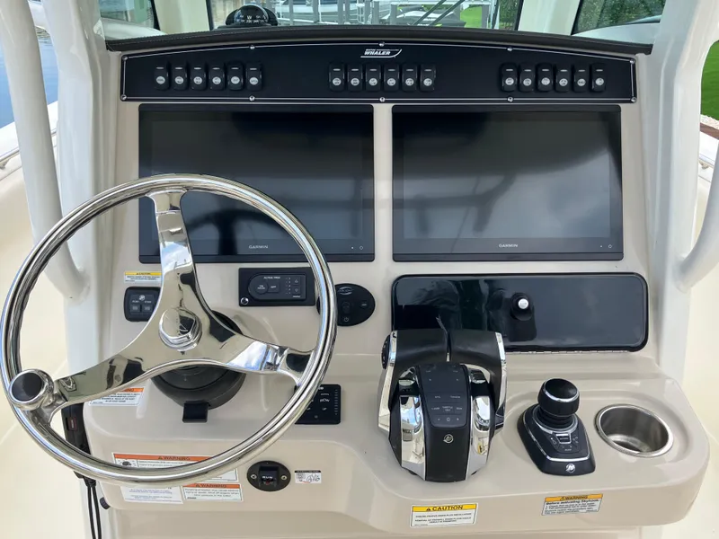 Slide: The Image of Control panel of a 2020 Boston Whaler 280 Outrage boat with dual screens and steering wheel. - 36