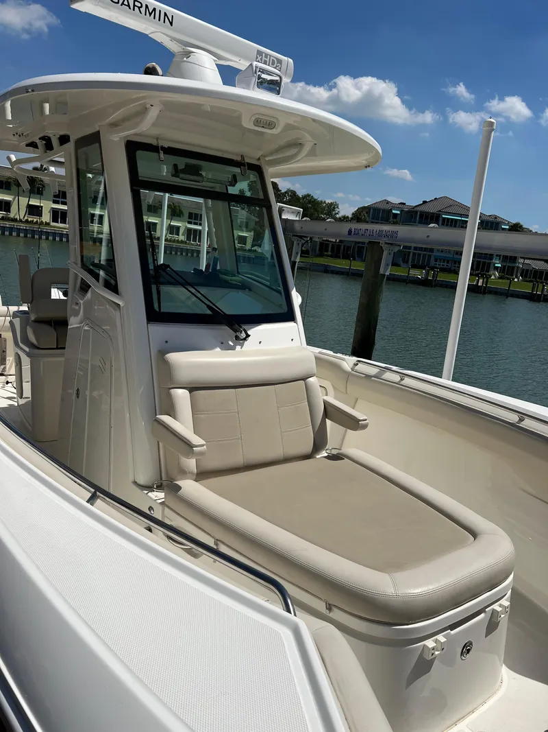 Slide: The Image of 2020 Boston Whaler 280 Outrage boat with seating, docked by waterfront homes. - 39