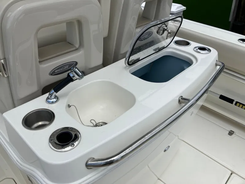 Slide: The Image of Boston Whaler 280 Outrage 2020 boat sink and storage area with faucet and cup holders. - 40