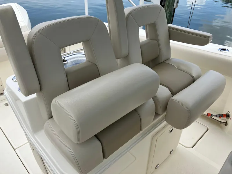 Slide: The Image of 2020 Boston Whaler 280 Outrage boat seats with beige upholstery, docked by water. - 42