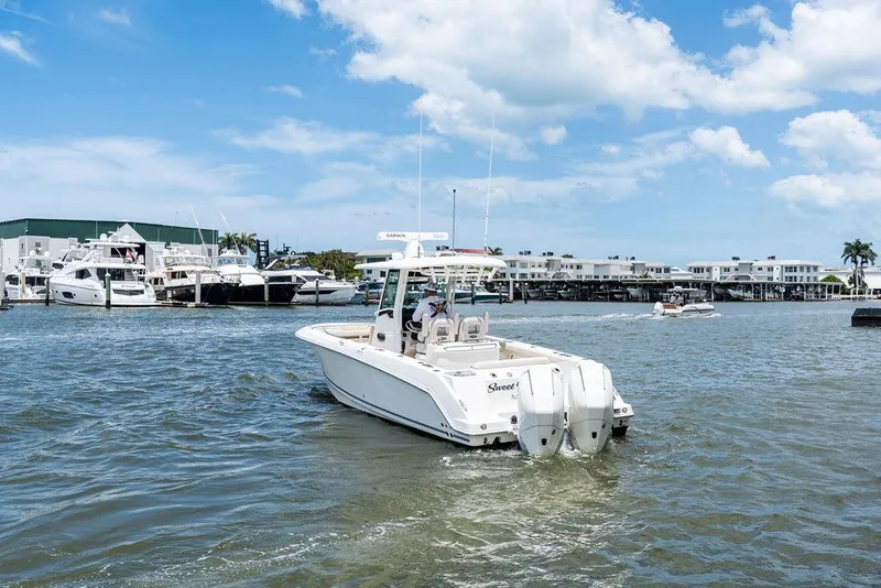 Slide: The Image of 2020 Boston Whaler 280 Outrage boat cruising in a marina under a blue sky. - 5