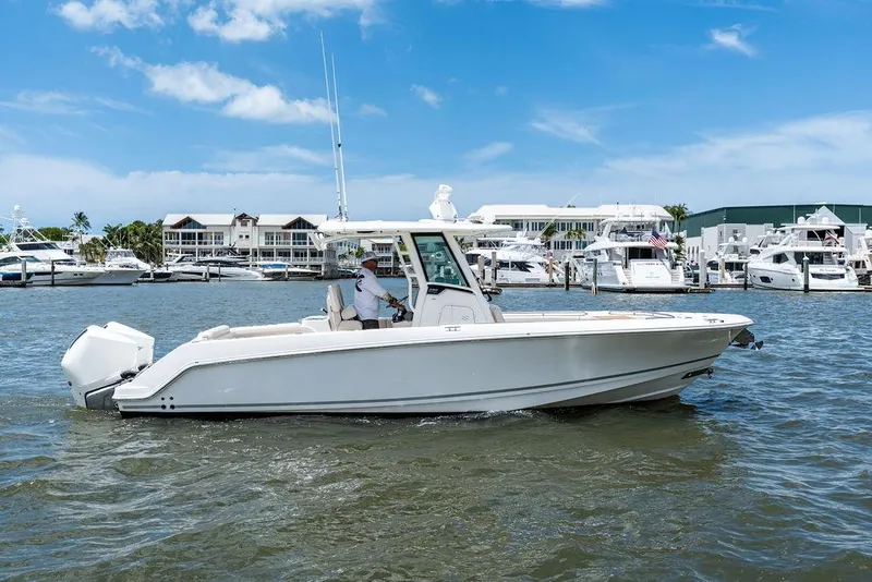 Slide: The Image of 2020 Boston Whaler 280 Outrage boat cruising in a marina under a clear blue sky. - 8