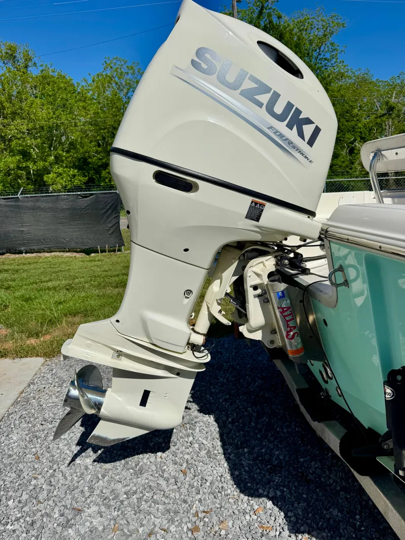 Slide: The Image of 2018 Bulls Bay 2200 with Suzuki outboard motor, parked on gravel near grass. - 4