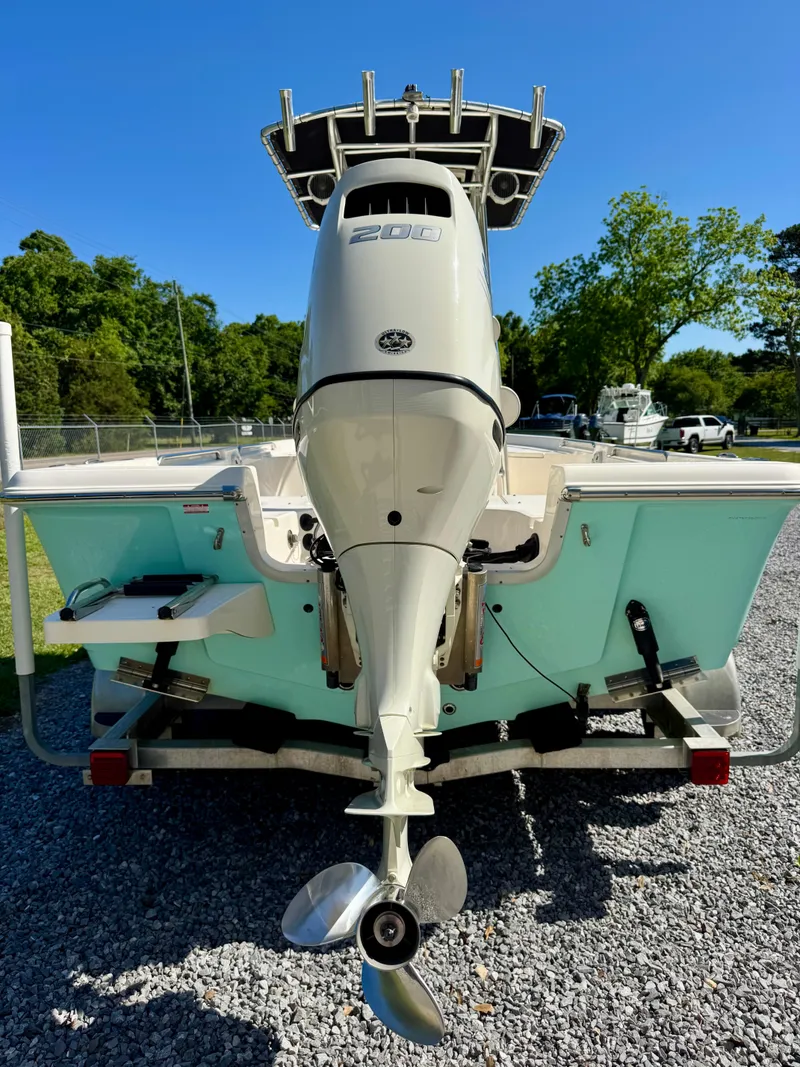 Slide: The Image of 2018 Bulls Bay 2200 boat with outboard motor, parked on gravel, under clear blue sky. - 5