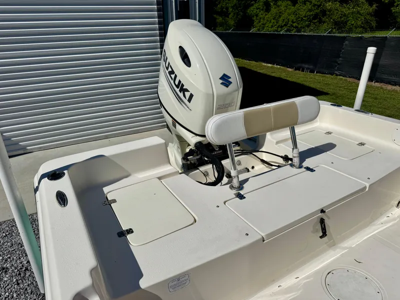 Slide: The Image of 2018 Bulls Bay 2200 boat with Suzuki outboard motor, parked near a metal garage door. - 9
