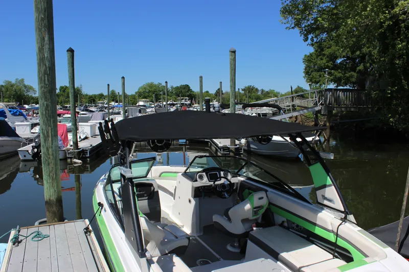 Slide: The Image of 2017 Chaparral Vortex 2430 VRX boat docked at a marina under clear blue skies. - 3