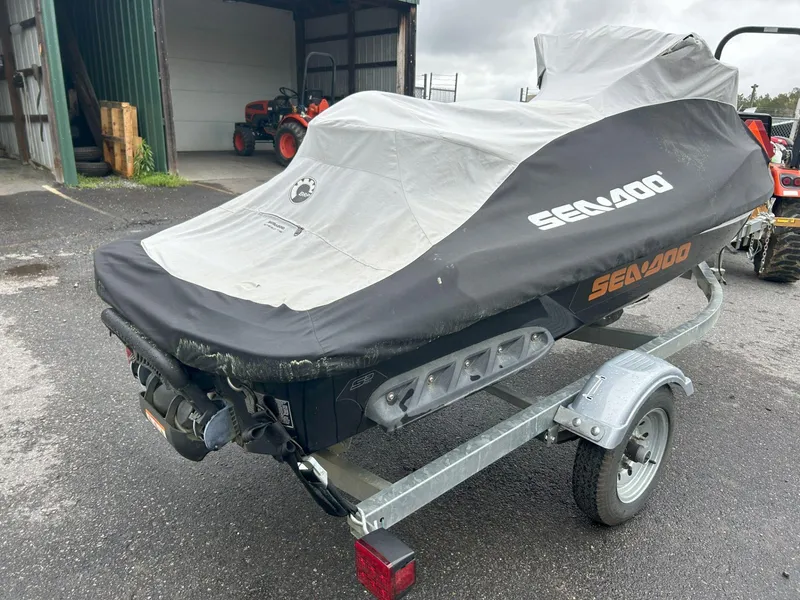 Slide: The Image of 2015 Sea-Doo GTX 155 jet ski covered on trailer in outdoor setting. - 27