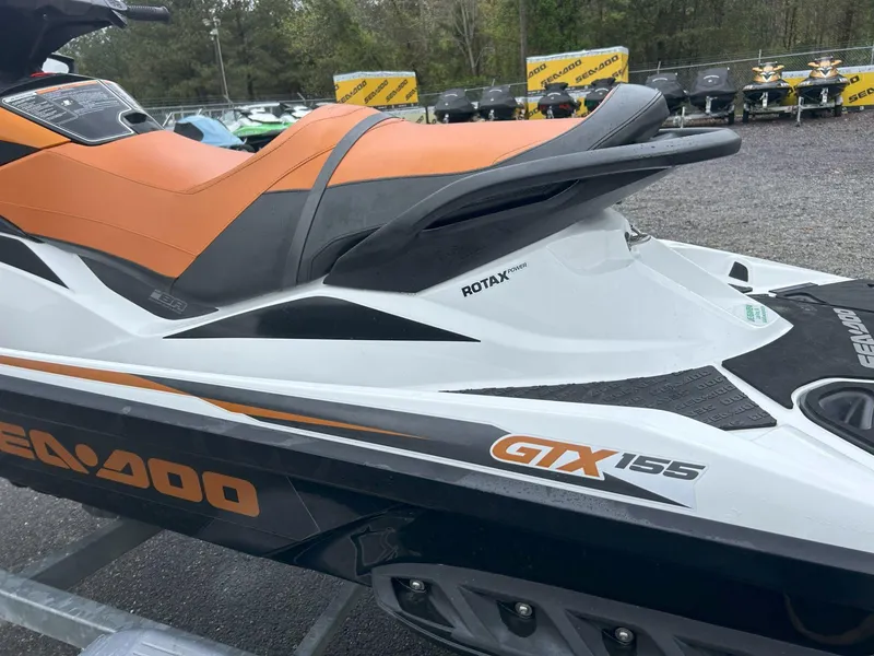 Slide: The Image of 2015 Sea-Doo GTX 155 jet ski with orange seat, displayed outdoors. - 4
