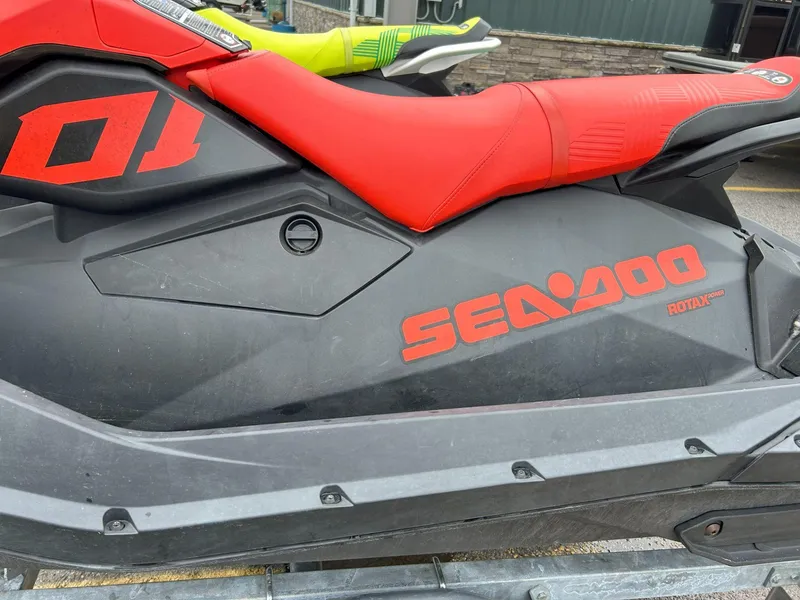Slide: The Image of 2021 Sea-Doo Spark Trixx 3up with red seat and branding, parked outdoors. - 7