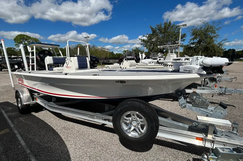 The Image of 2025 Mako 18 Pro Skiff Patriot Edition boat on trailer under blue sky. - 0
